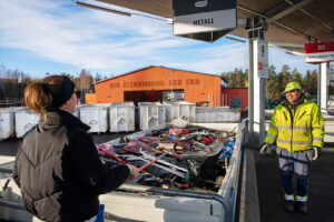 Personal på Vallentuna returpark samtalr med kund över Metallcontainern